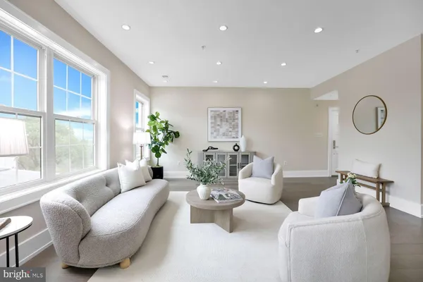 a living room with furniture potted plant and windows