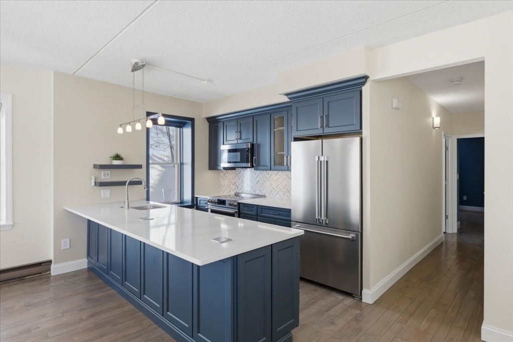 7A Eugene Circle, Unit B Boston, MA 02130 - Photo 10 of 42 a kitchen with kitchen island a sink refrigerator and microwave