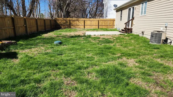 a view of backyard with wooden fence