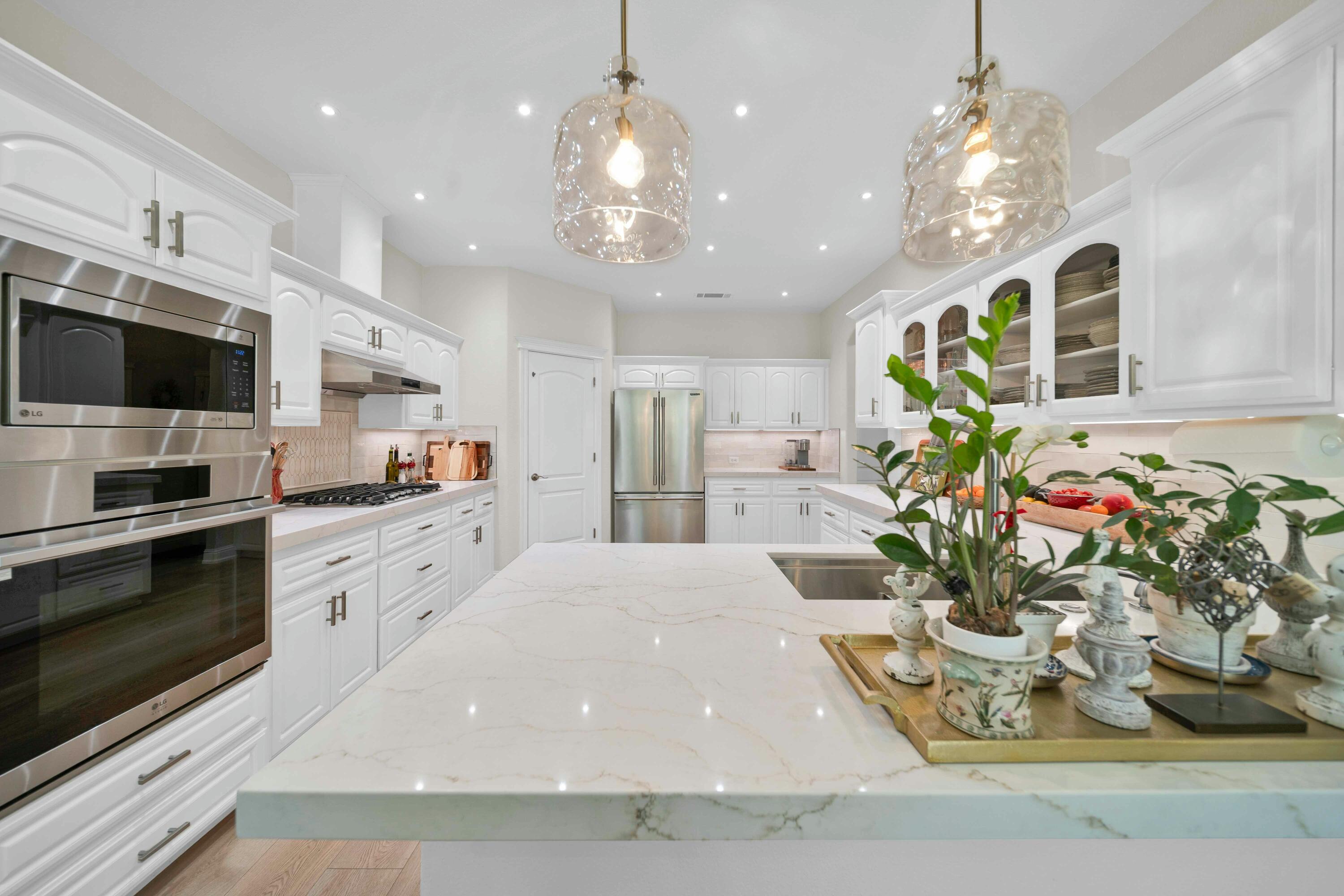 4045 Mt Whitney Way Redding, CA 96002 - Photo 28 of 78 a kitchen with stainless steel appliances kitchen island granite countertop a stove a sink a refrigerator and a dining table with wooden floor