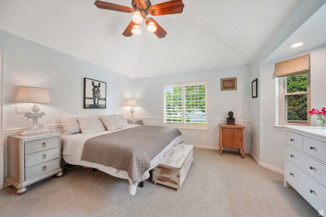 357 South 320 W Street Lindon, UT 84042 - Photo 11 of 41 Vaulted ceiling room featuring a wood-finish ceiling fan with integrated lighting, multiple windows with white plantation shutters, and light-toned carpet flooring