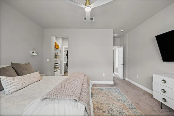 a spacious bedroom with a bed and a flat screen tv