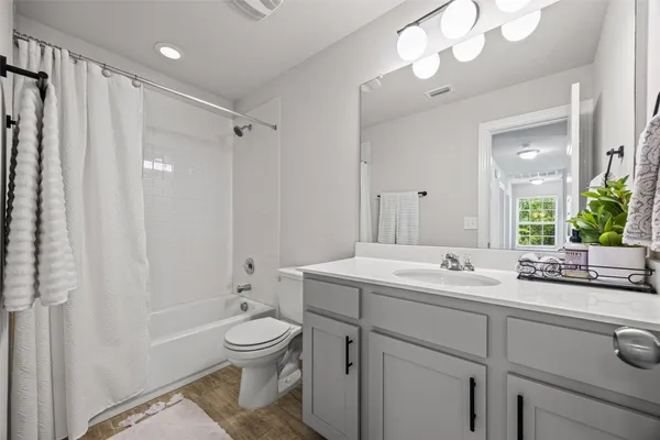 a spacious bedroom with a bed and a chandelier