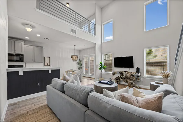 a living room with furniture kitchen view and a flat screen tv