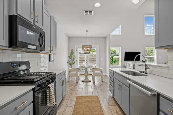 a kitchen with stainless steel appliances a stove sink microwave and cabinets