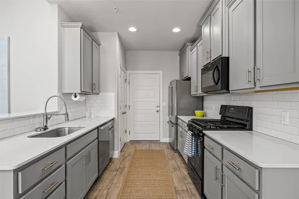 a kitchen with stainless steel appliances granite countertop a sink stove and refrigerator