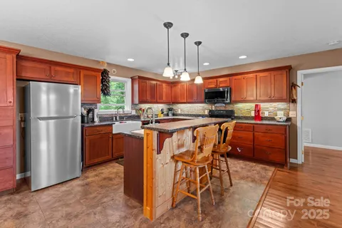 a kitchen with stainless steel appliances a refrigerator a stove a sink dishwasher with a dining table and chairs