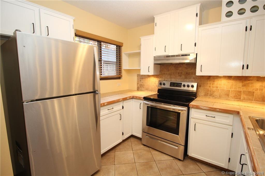7 Woods Way, Unit 7 Woodbury, CT 06798 - Photo 2 of 19 a kitchen with stainless steel appliances a refrigerator sink and cabinets