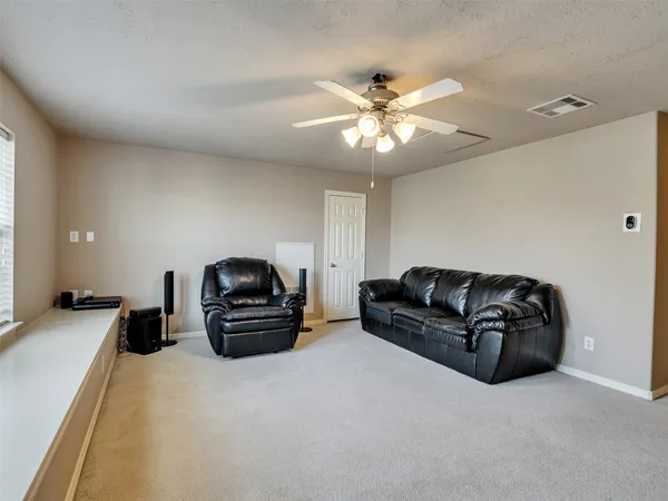 a living room with furniture and a ceiling fan