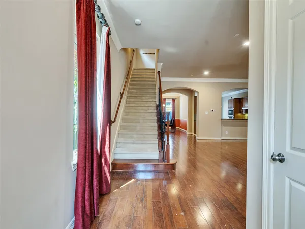 a view of a hallway with wooden floor and staircase