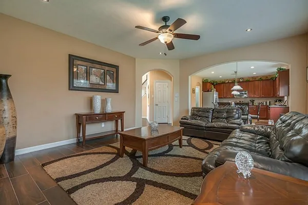a living room with furniture and a ceiling fan