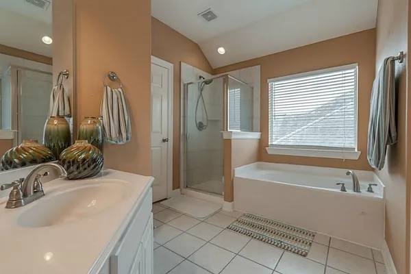 a bathroom with a tub sink and mirror