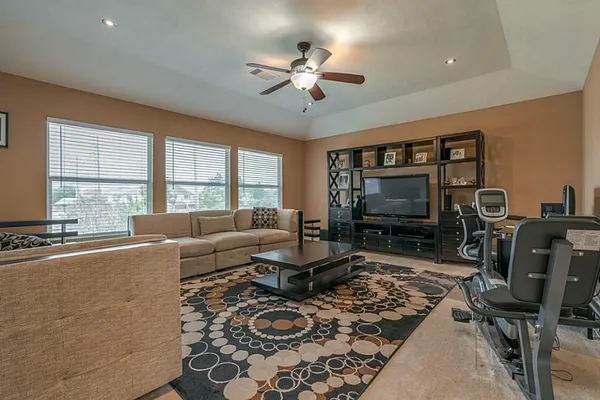 a living room with furniture a flat screen tv and a large window