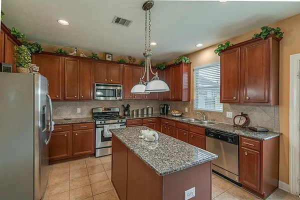 a kitchen with stainless steel appliances granite countertop a sink stove and refrigerator