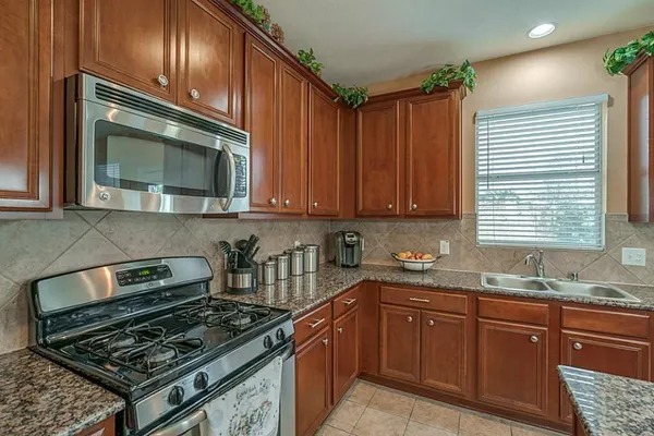 a kitchen with granite countertop a stove and a sink