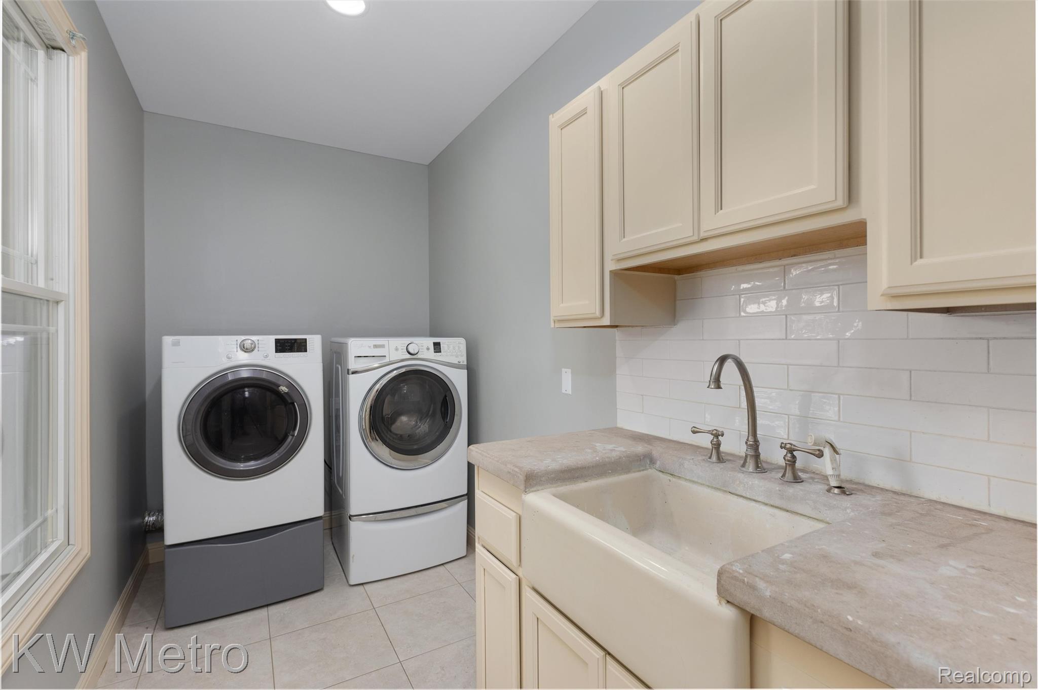 65884 Windrose Court Ray, MI 48096 - Photo 66 of 82 Laundry area featuring washer and dryer, light tile patterned floors, and cabinet space