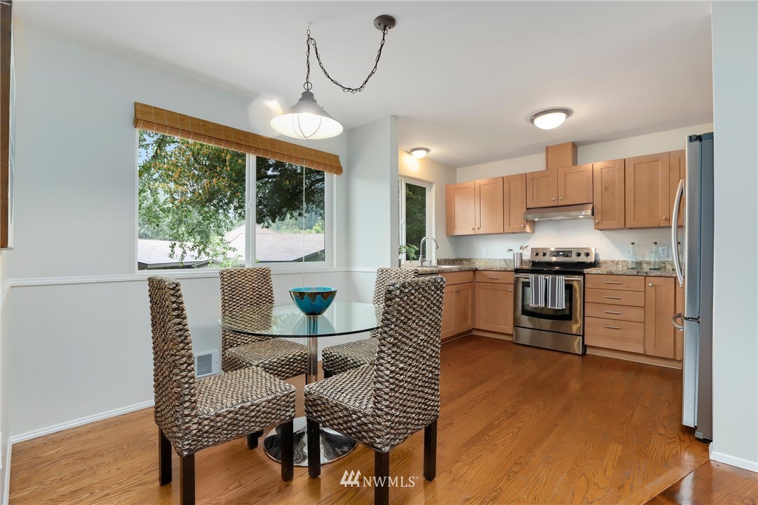 17830 28th Avenue Southeast Bothell, WA 98012 - Photo 8 of 25 a kitchen with granite countertop kitchen island stainless steel appliances a table and chairs in it