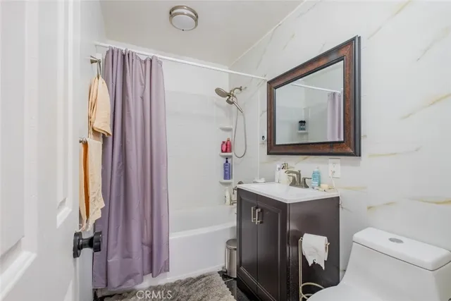 a bathroom with a toilet sink vanity tub and mirror