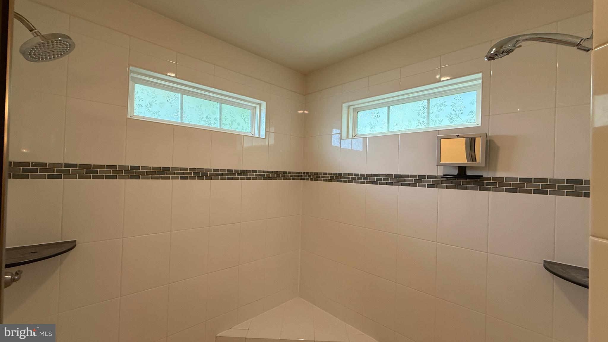 12421 Mays Quarter Road Woodbridge, VA 22192 - Photo 18 of 30 a bathroom with a granite countertop window and a shower