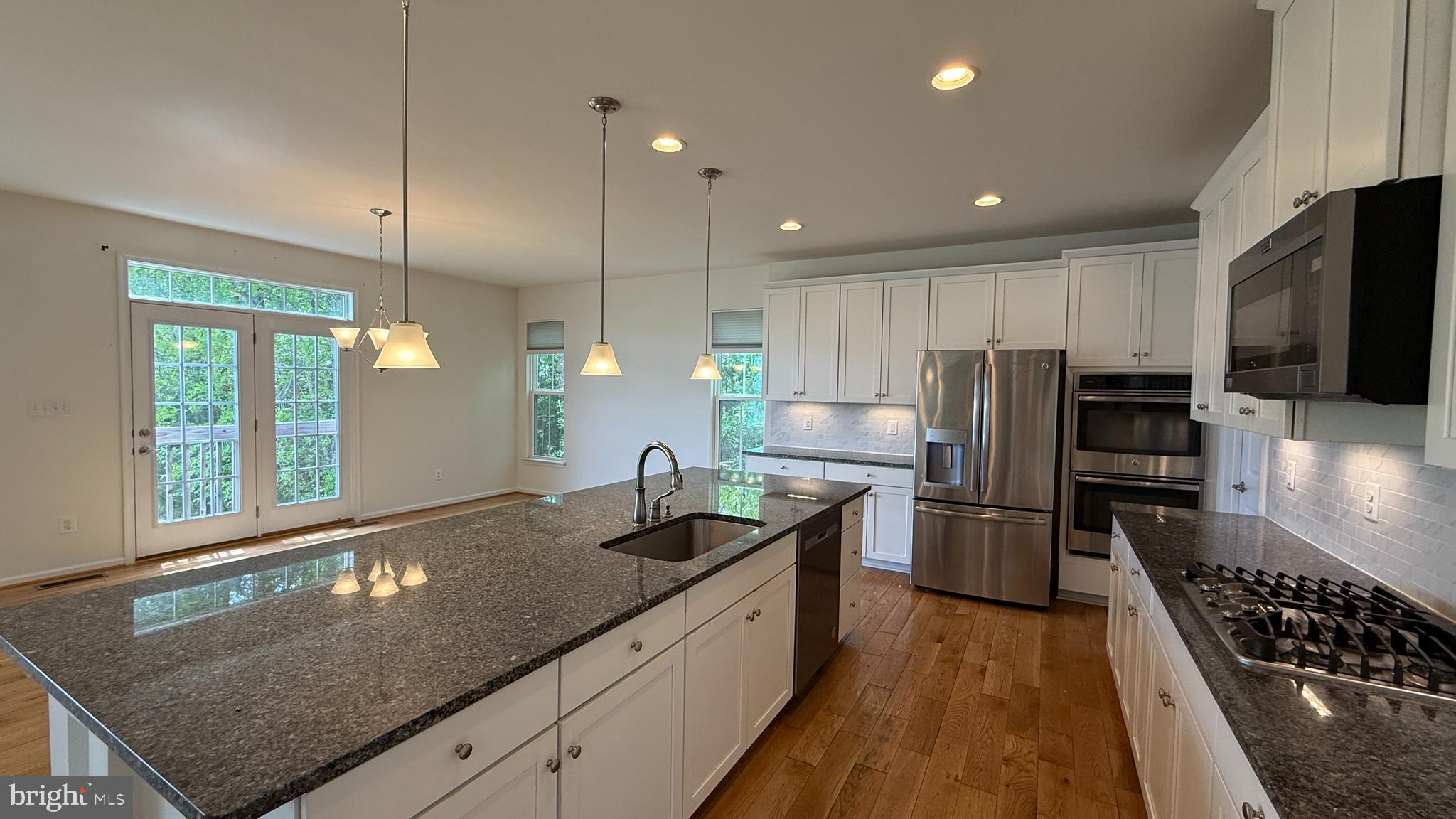 12421 Mays Quarter Road Woodbridge, VA 22192 - Photo 5 of 30 a kitchen with stainless steel appliances granite countertop a sink a stove and a refrigerator