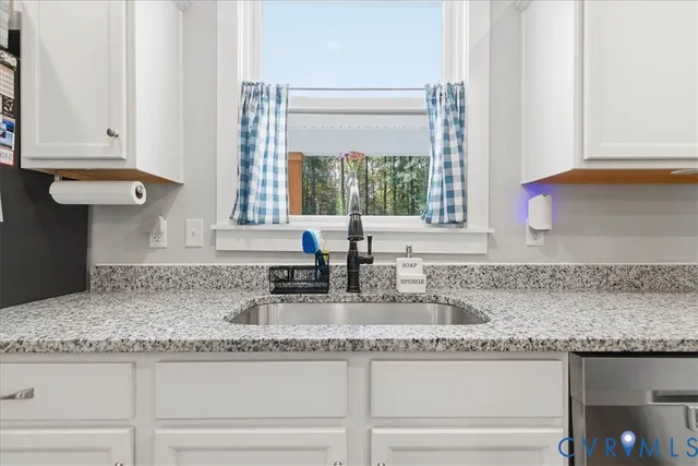 a kitchen with granite countertop a sink and a window