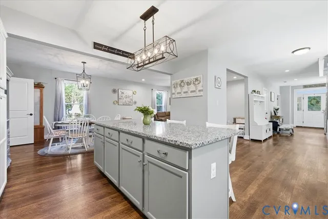 a kitchen with stainless steel appliances granite countertop a oven a stove and a wooden floors
