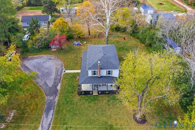 an aerial view of a house with a yard and large trees