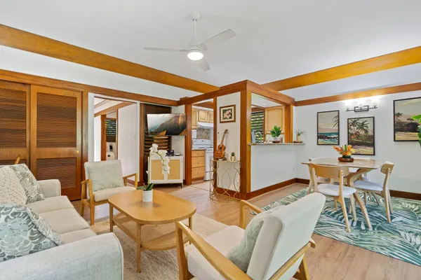 a living room with furniture a dining table and chairs with wooden floor