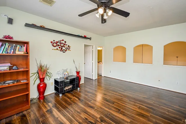 a living room with furniture a dining table and paintings on the wall