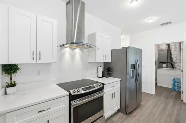 a kitchen with stainless steel appliances white cabinets and a refrigerator