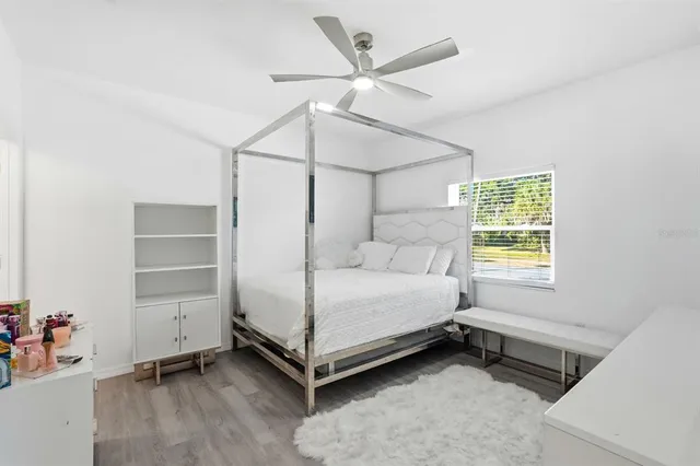 a bedroom with a bed and a ceiling fan