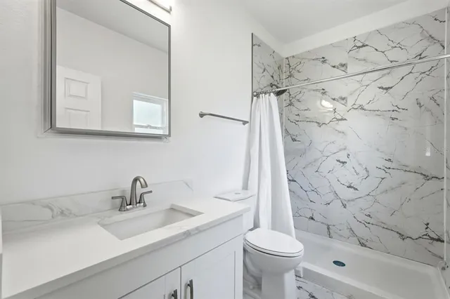 a bathroom with a sink toilet and shower