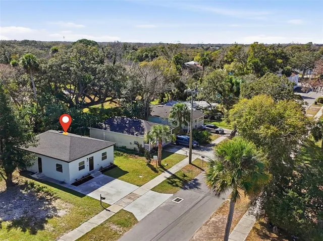 an aerial view of a house with swimming pool and mountains