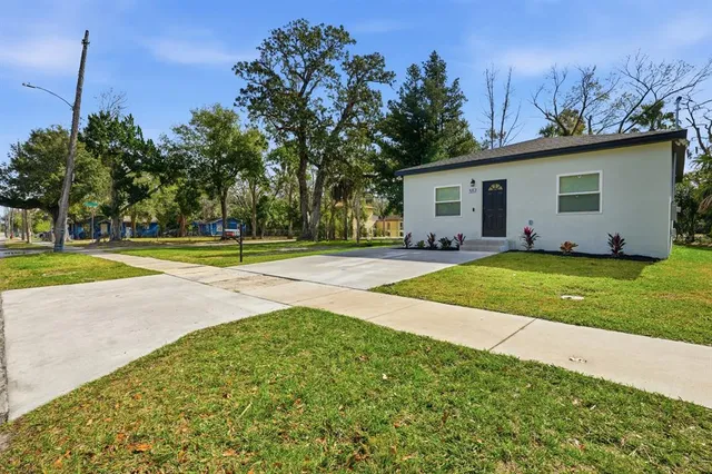 a view of a house with a yard and tree s