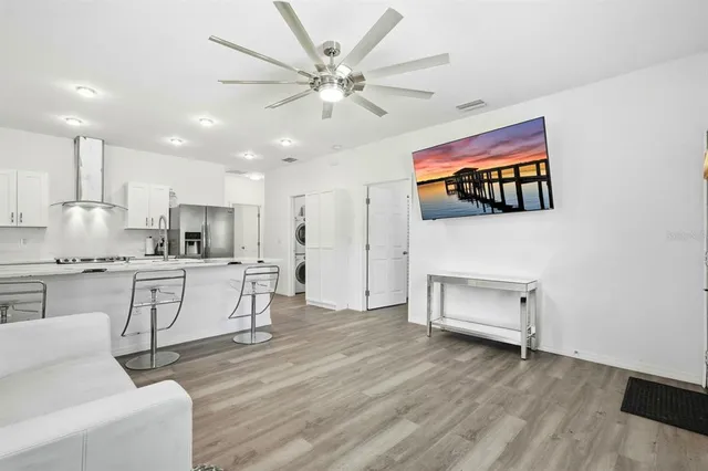 a open kitchen with white cabinets and wooden floor