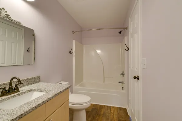 a bathroom with a granite countertop sink toilet and shower