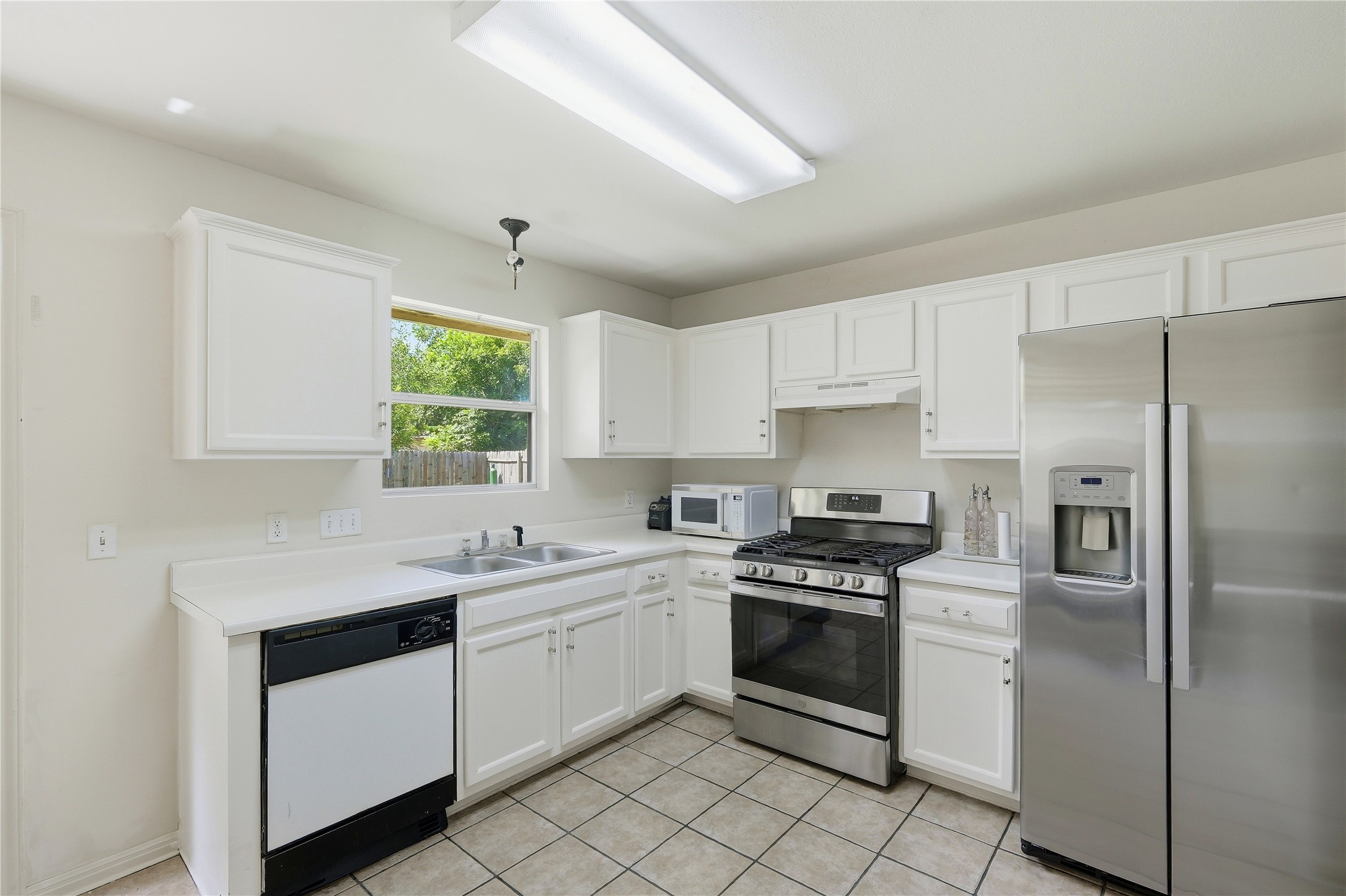 310 Raintree Drive Georgetown, TX 78626 - Photo 5 of 12 A well-equipped culinary space awaits with pristine white cabinetry and essential appliances.