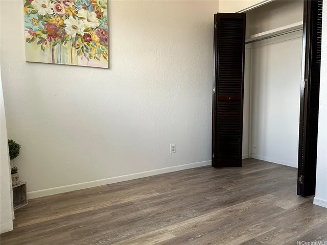an empty room with wooden floor and closet