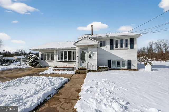 a front view of a house with a yard covered in snow