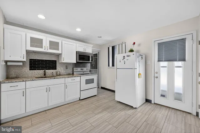 a kitchen with stainless steel appliances a refrigerator sink and white cabinets