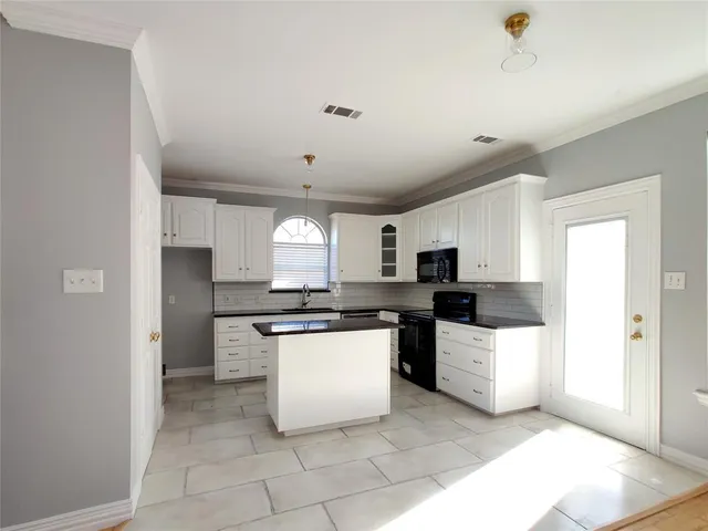 a kitchen with stainless steel appliances a sink a stove a refrigerator and cabinets