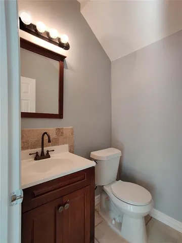 a bathroom with a toilet a sink and mirror