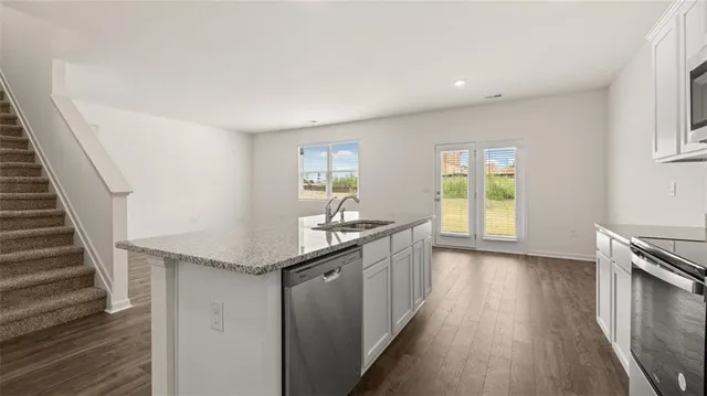 a kitchen with granite countertop a sink and a stove top oven