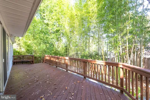 a view of backyard with green space and wooden fence