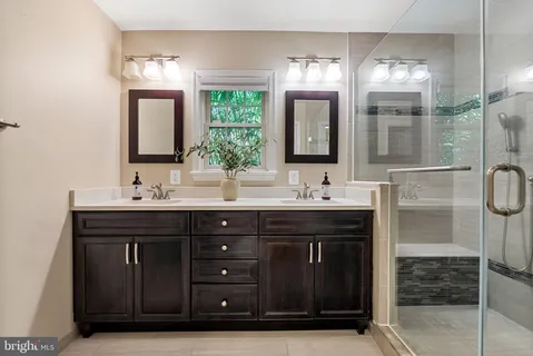 a bathroom with a double vanity sink and a mirror