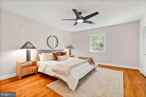 a bedroom with a bed and a lamp on dresser