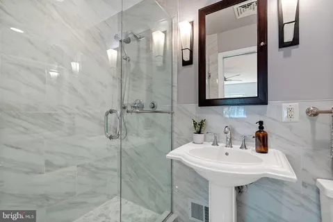 a bathroom with a sink a mirror and shower