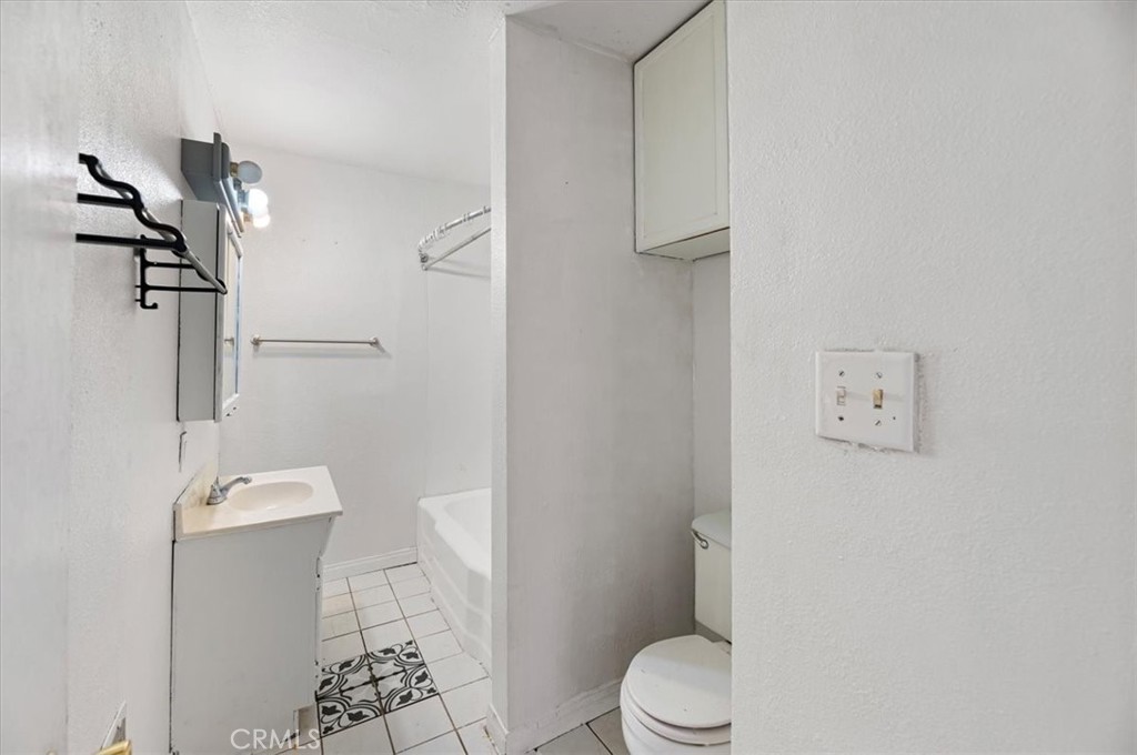 44340 Foxton Avenue Lancaster, CA 93535 - Photo 12 of 25 a white toilet sitting next to a bathroom sink