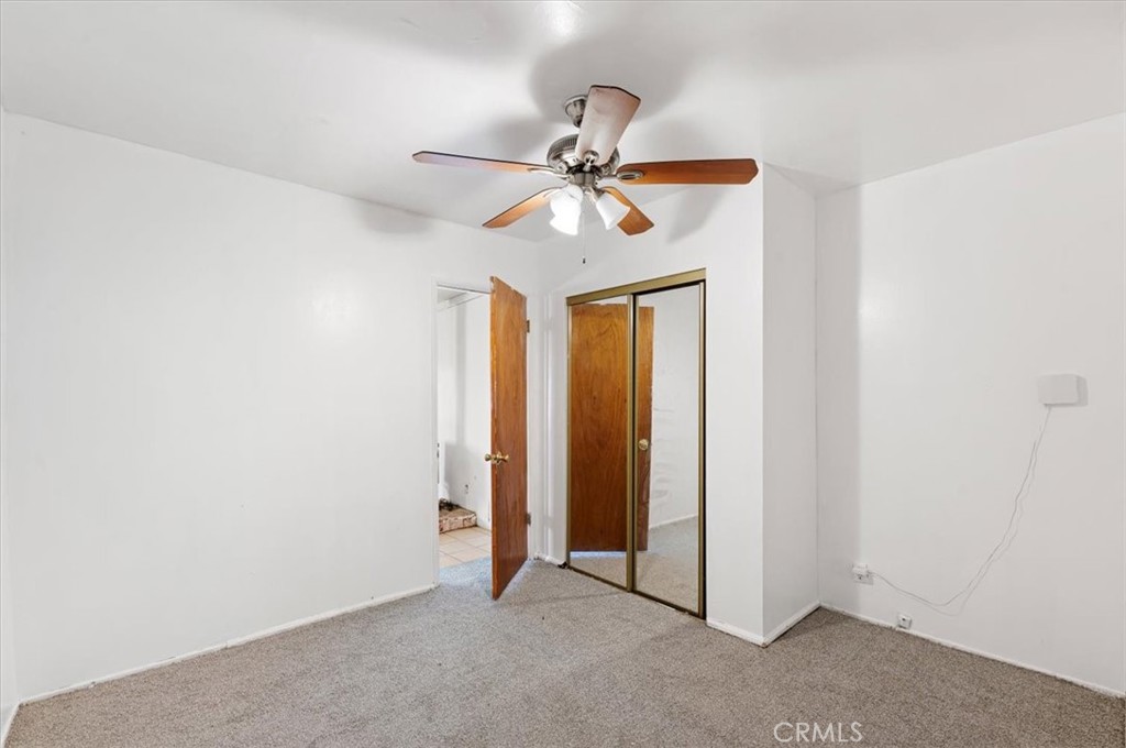 44340 Foxton Avenue Lancaster, CA 93535 - Photo 15 of 25 an empty room with closet and a chandelier fan