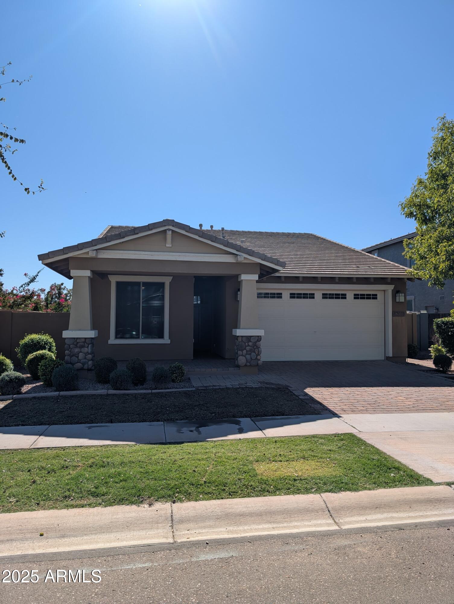 a front view of a house with a garden and yard